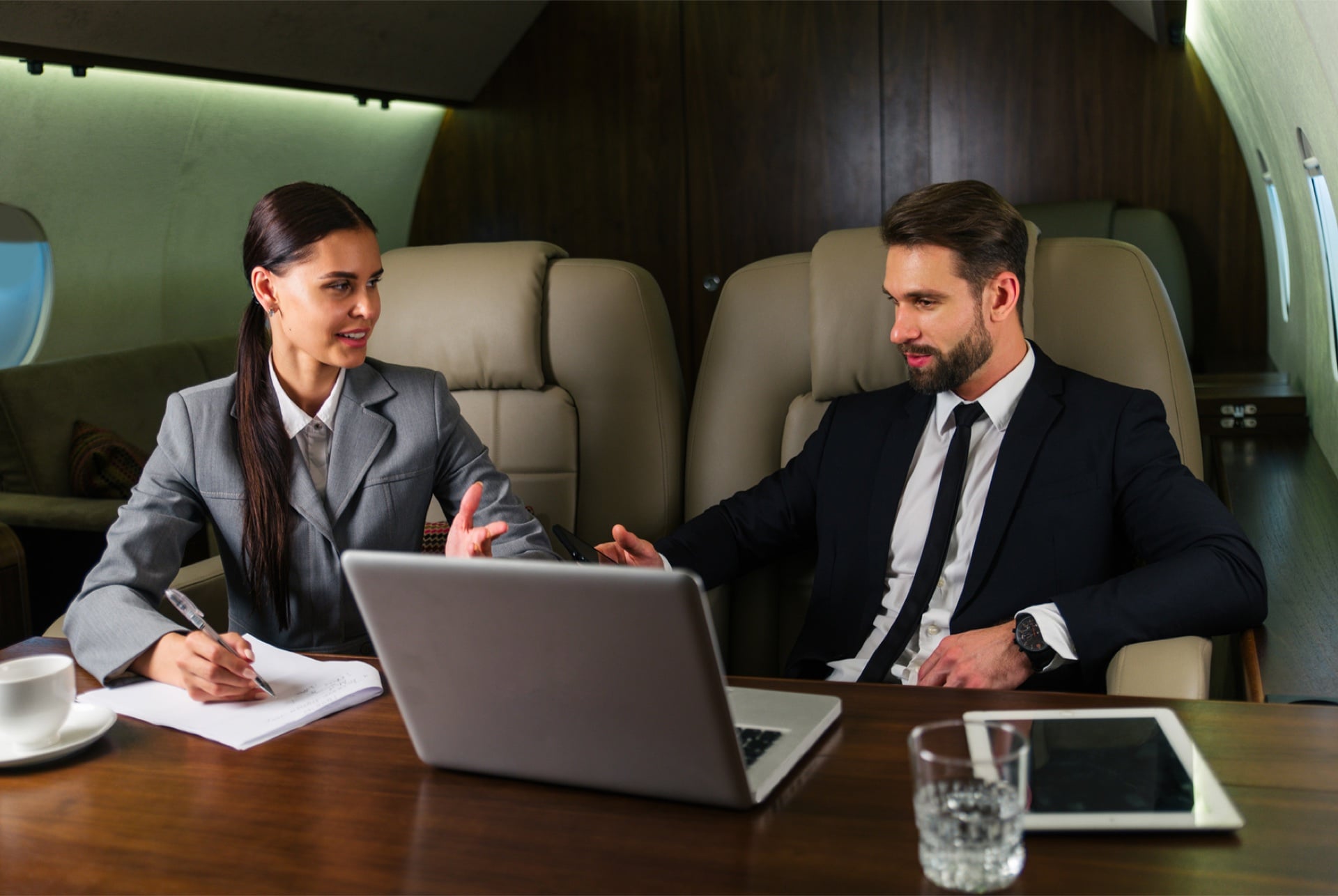 Two aviation advisors reviewing a charter booking in a private jet cabin